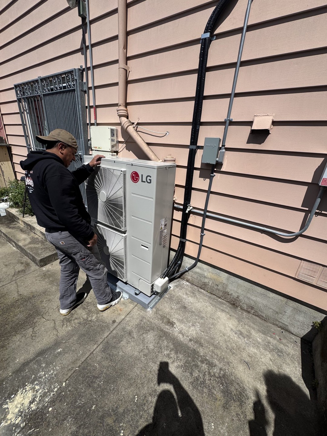 A technician commissioning a new heat pump outside a home